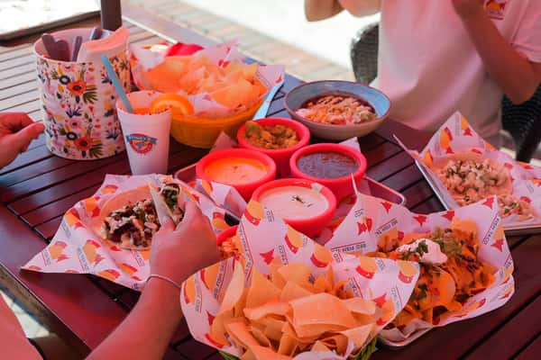 Table filled with tacos, chips, salsa, and shareable Mexican favorites.