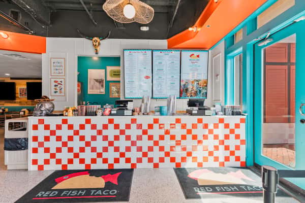 Fast casual restaurant counter with colorful tile accents and menu boards.