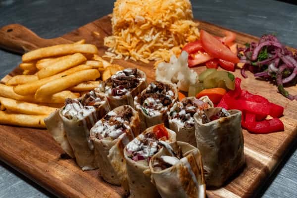 Grilled beef shawarma wraps with garlic sauce, served with fries, shredded cheese, tomatoes, onions, and assorted pickled veggies.