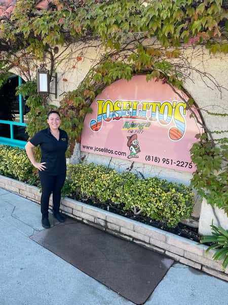 Celina Jimenez, General Manager of Joselito's Mexican Restaurant in Los Angeles, standing in front of the ivy-covered exterior of the restaurant.