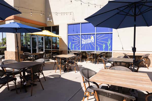 An outdoor dining area with tables and blue umbrellas.