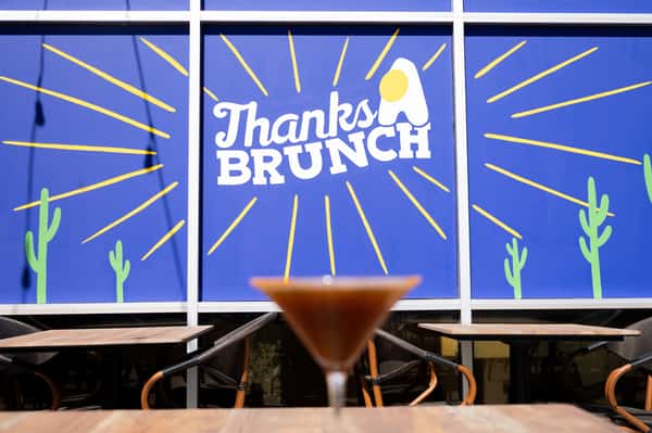 A wall mural featuring white line art and the "Thanks Brunch" logo against a blue background.