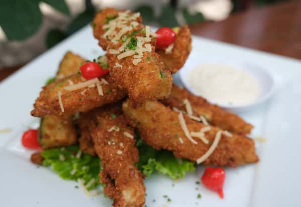 Crispy fried zucchini topped with shredded parmesan, garnished with mini peppers, served with creamy dipping sauce.