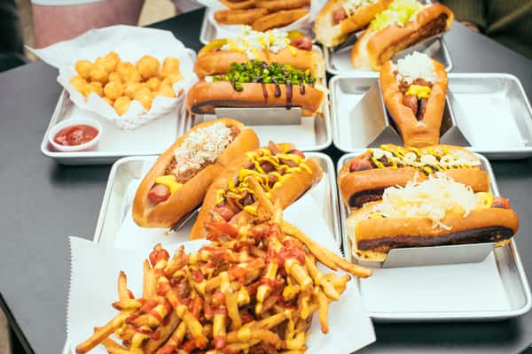 Variety of different hot dog styles, fries, tots and other sides