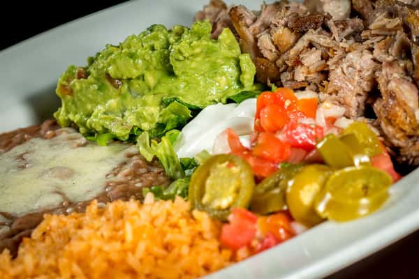 Carnitas Platillo: Traditional Mexican style deep-fried pork. Served with guacamole and sour cream.