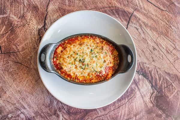 A hearty meat lasagna baked with layers of rich meat sauce, creamy cheese, and melted mozzarella, finished with a golden, bubbly crust. Served in an individual baking dish, this Italian classic is warm, comforting, and full of homemade flavor.