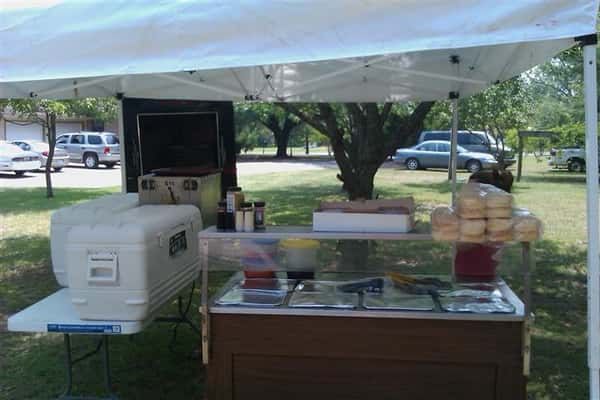 Picnic tent with tables and food under it