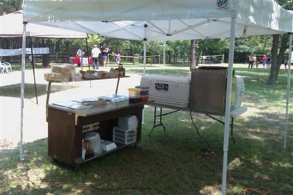Picnic tent with tables and food under it