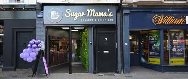 Sugar Mama's Dessert & Drink Bar storefront with gray signage, purple balloons, and glass entrance on city street