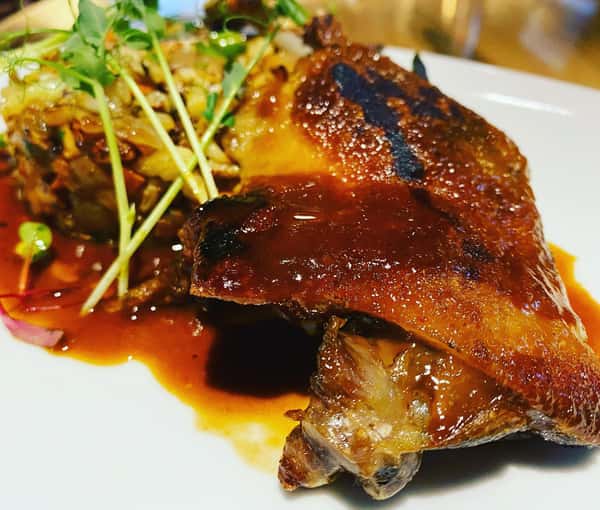 House Duck leg confit with a sesame orange glaze with cauliflower and vegetable “fried rice”