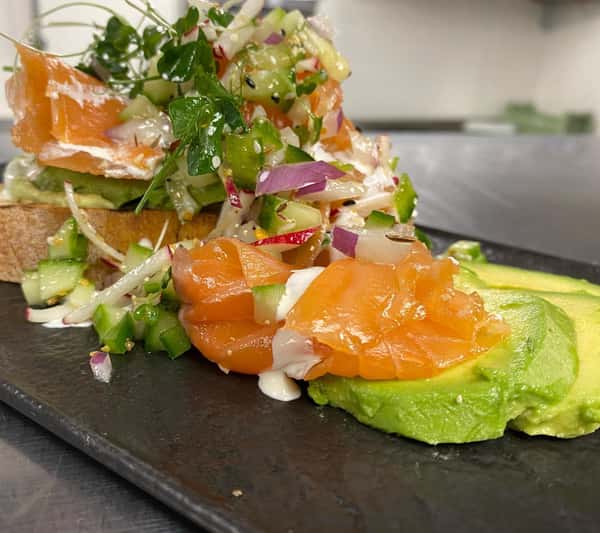 Bourbon and fennel cured salmon, avocado and edamame toast, bagel spice micro green and vegetable salad