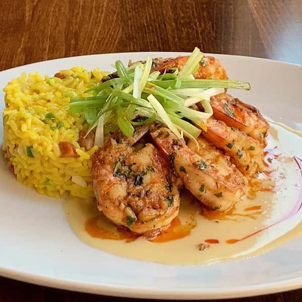 Sautéed Jumbo garlic shrimp with chorizo saffron paella rice and red chili oil.