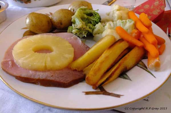 Baked ham steak topped with pineapple ring served with roasted potatoes, carrots, and broccoli.