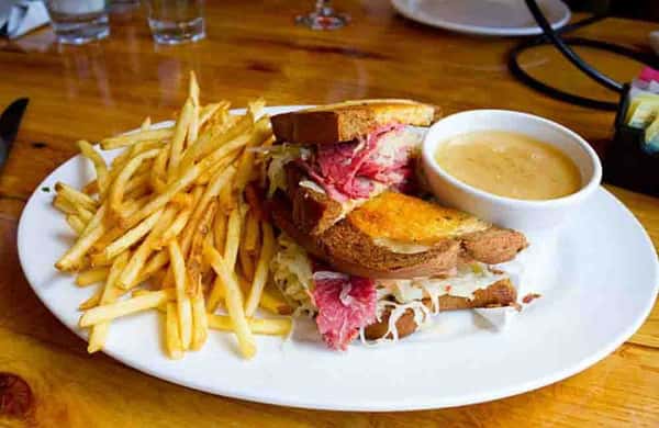 Hearty deli-style sandwich stacked with corned beef and coleslaw, served with French fries and dipping sauce.