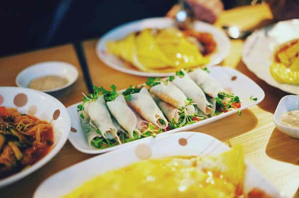 Platter of fresh Vietnamese spring rolls with herbs and vegetables served with dipping sauce.