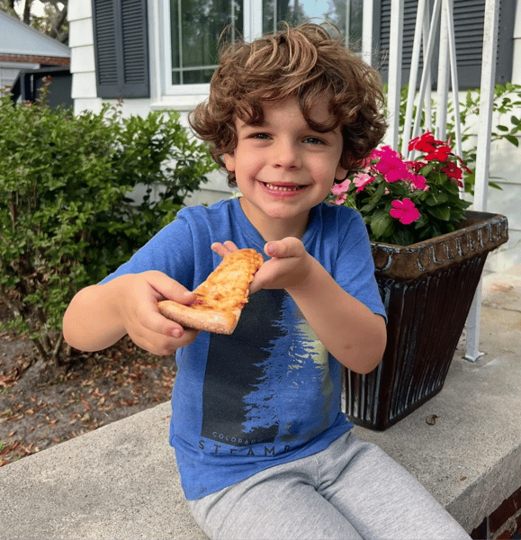 kid with a slice of pizza in his hands
