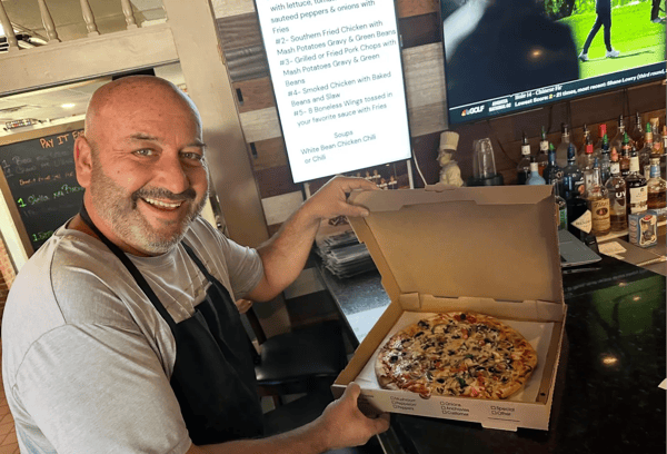 man showing a pizza in the box