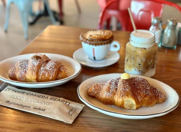 Two croissants and dulccino coffee on table