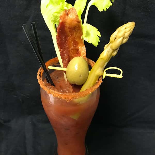 a bloody mary with asparagus, celery, bacon, and green olive