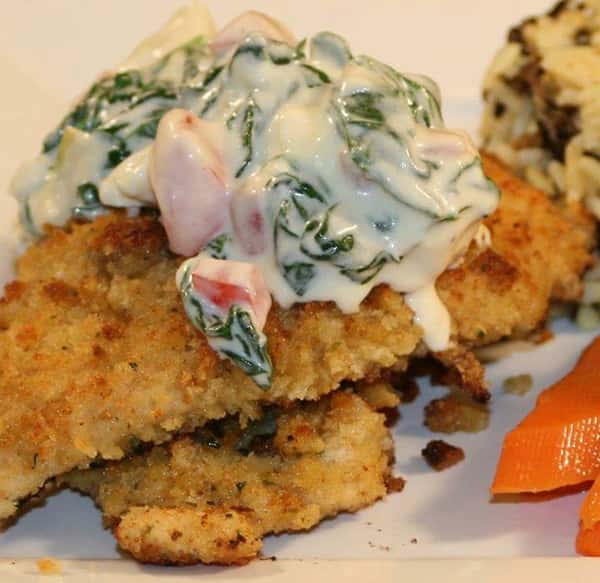 breaded chicken with creamed spinach on top
