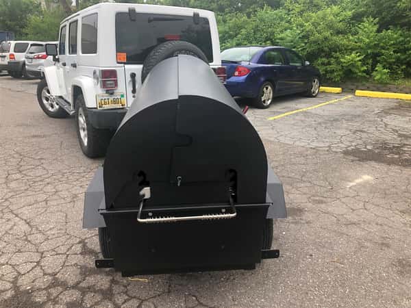 grill hooked up to the back of a white jeep