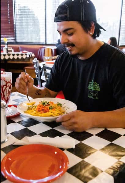 a customer eating ziti pasta at the diner