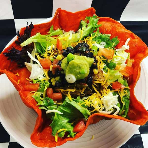 a taco salad in a red taco shell