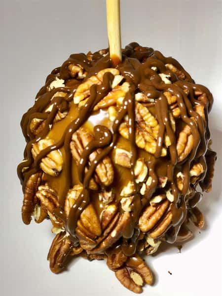 caramel apple covered in pecans and chocolate drizzle