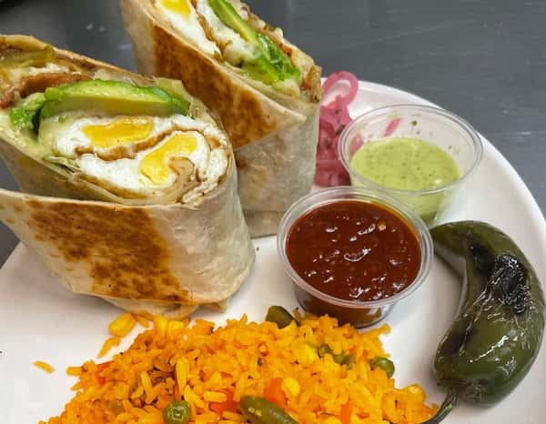 Delicious breakfast burrito stuffed with eggs, avocado, and cheese, served with Mexican rice, grilled jalapeño, pickled onions, and two types of salsa at Tacos Chano.