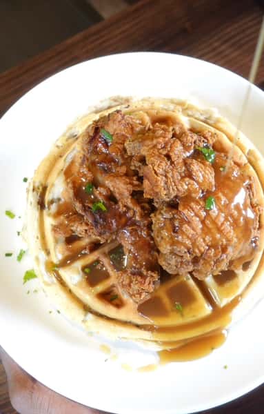 waffle and chicken with sauce on top