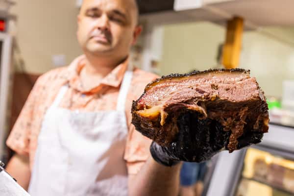 A man showing a brisket piece