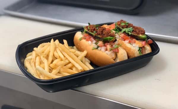 sausage on a roll topped with onions, tomatoes, cilantro, jalapenos, shredded beef and a side of French fries