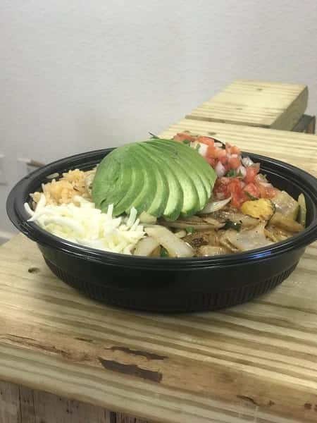 A burrito bowl topped with avocado, cheese, brown rice, pico de gallo, and grilled onion