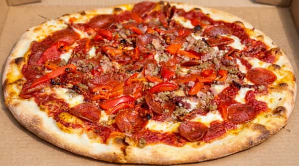 Pepperoni and sausage pizza with red bell peppers and melted cheese on a lightly browned crust.