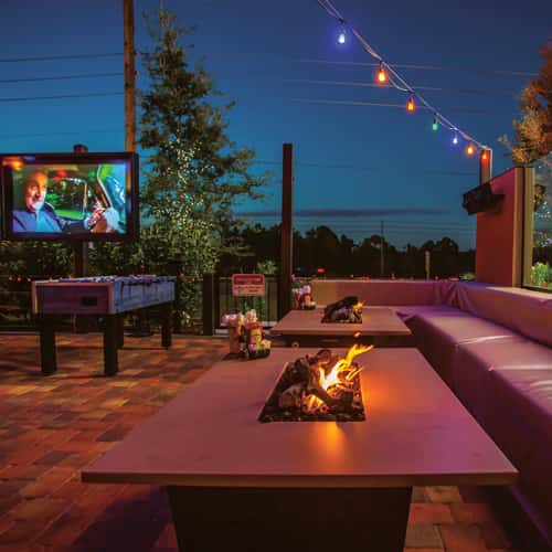 Climate-controlled covered patio with overhead fans and long tables set for a group dinner in Oviedo, FL