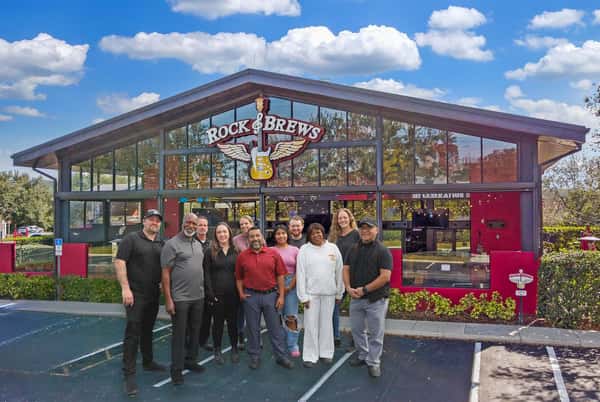 Photo shows the Rock & Brews Oviedo Staff standing outside of the building in the parking lot.
