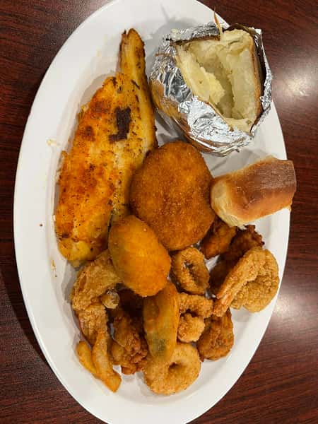 Seafood platter with fried fish, shrimp, hush puppies and a baked potato