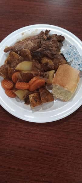 Pot roast with potatoes, carrots and a dinner roll