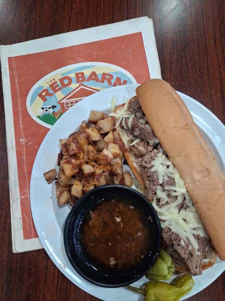 Philly cheesesteak sub with home fries and au jus