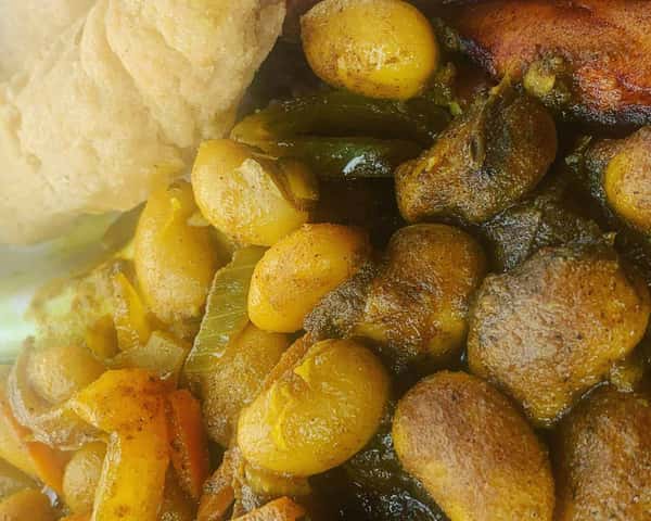 Jamaican stew peas with dumplings, butter beans, and fried plantain, served with a piece of festival dumpling.
