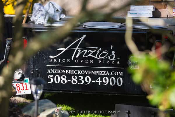 Anzio's Brick Oven Pizza sign on table at wedding