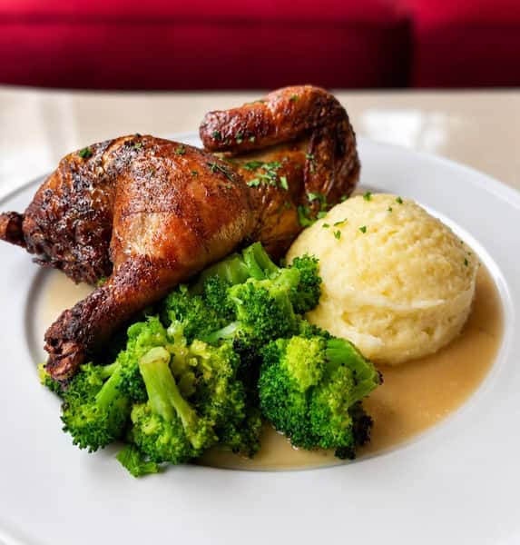 Half chicken served with mashed potatoes and broccoli