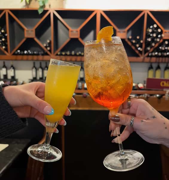 Two hands cheering cocktails