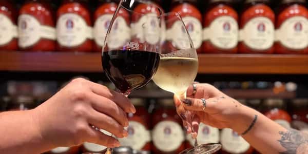 Two hands cheering glasses of wine