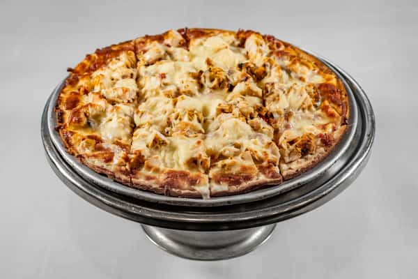 Freshly baked chicken pizza with golden crust, grilled chicken pieces, and melted mozzarella, presented on a raised silver pizza stand