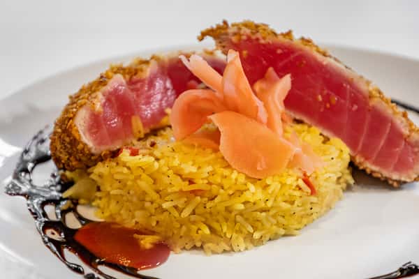 Sesame-crusted seared ahi tuna served rare over a bed of saffron rice, garnished with pickled ginger and finished with a drizzle of balsamic glaze.
