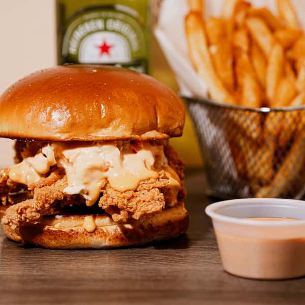 A golden-brown fried chicken breast topped with a tangy sauce
