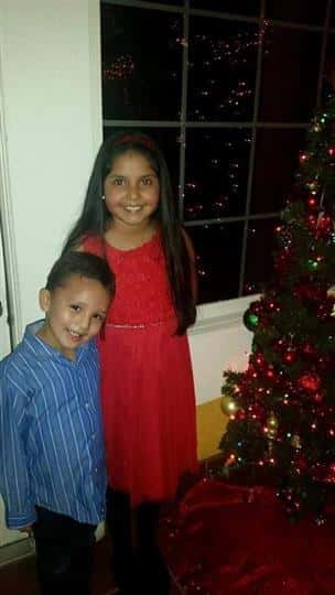 kids standing next to a christmas tree