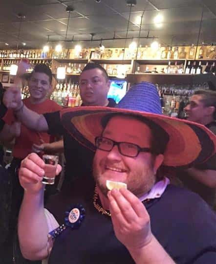 man wearing hat about to do a shot