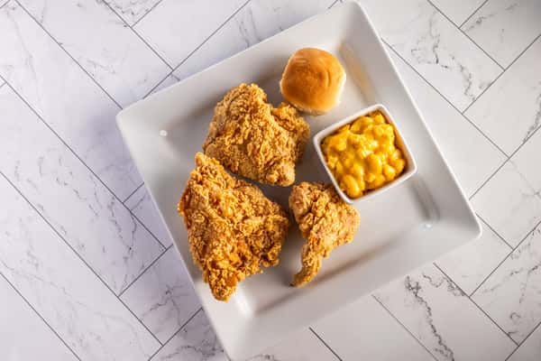 crispy Southern fried chicken plate with golden fried chicken pieces, creamy mac and cheese, and a soft dinner roll